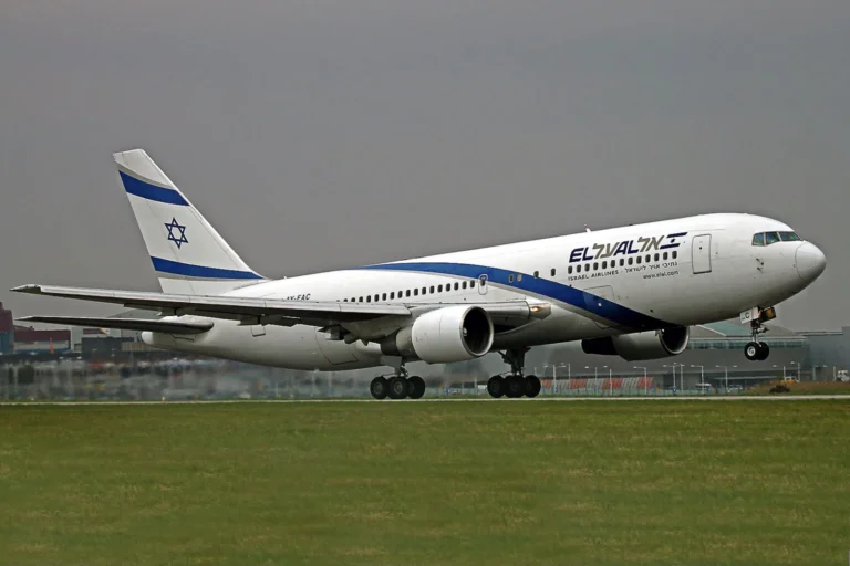 El Al passenger jet taking off from a runway with a white fuselage, blue stripe, and Star of David on the tail.