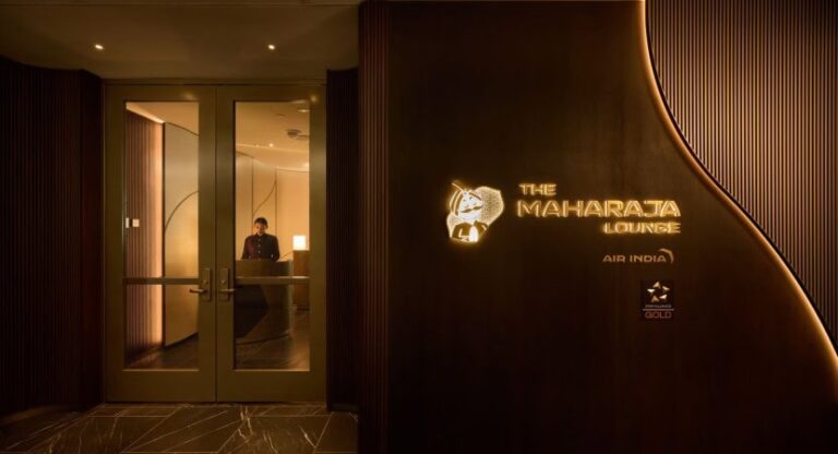 Entrance to The Maharaja Lounge by Air India, with glass doors and a receptionist visible inside the dimly lit lobby.