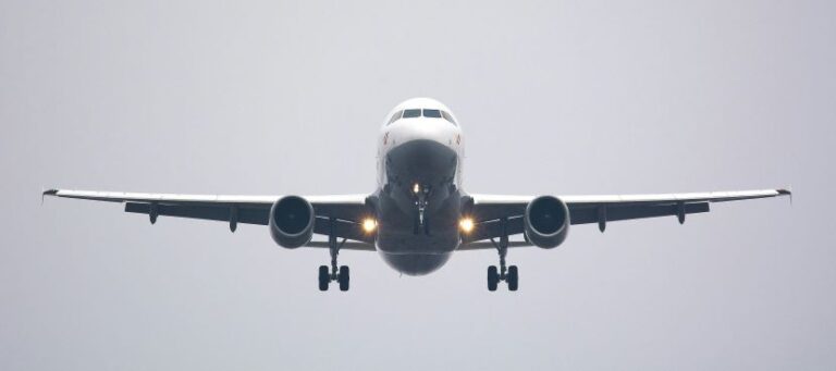 Passenger jet approaching head-on for landing with wheels down, centered in the frame.