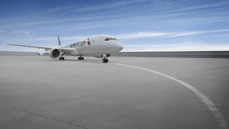 White American Airlines jet on a deserted airport tarmac under a blue sky.