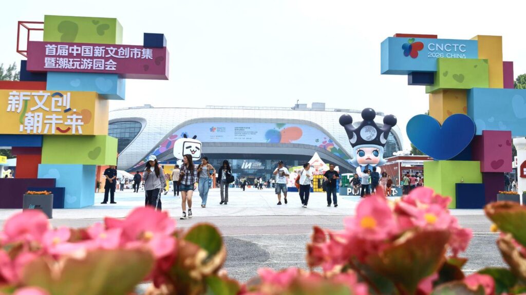 Colorful arch made of stacked blocks at the CNCTC 2026 China entrance, with visitors walking toward a modern expo building.