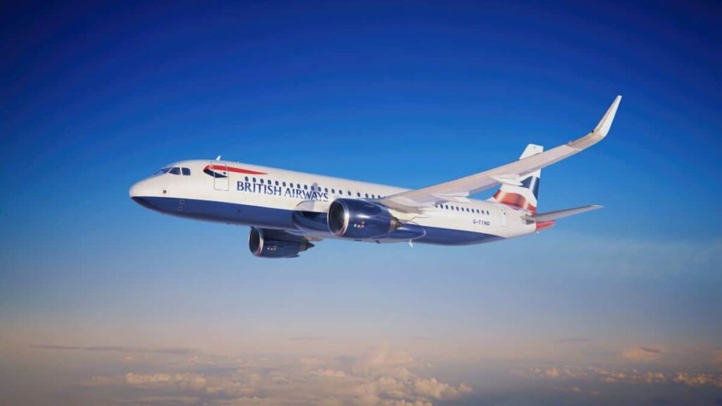 British Airways passenger jet flying above clouds against a bright blue sky.