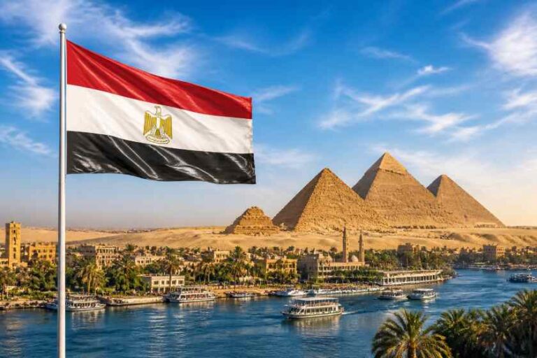 Egyptian flag waving in front of the pyramids by the Nile with boats docked along the riverbank