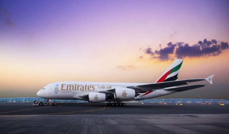 Emirates A380 on the taxiway at sunset, with the Gulf/UAE flag on the tail and Crew nearby aircraft nose shows 'Emirates'.