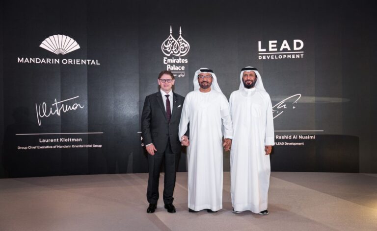 Three men on a stage posing for a photo with a dark backdrop showing Mandarin Oriental, Emirates Palace, and LEAD Development logos.