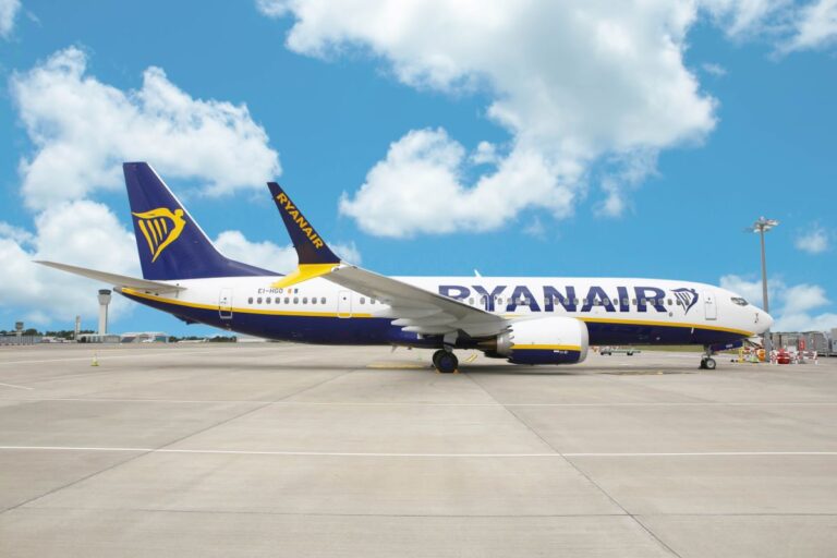 Ryanair airplane parked on the airport tarmac under a clear blue sky.