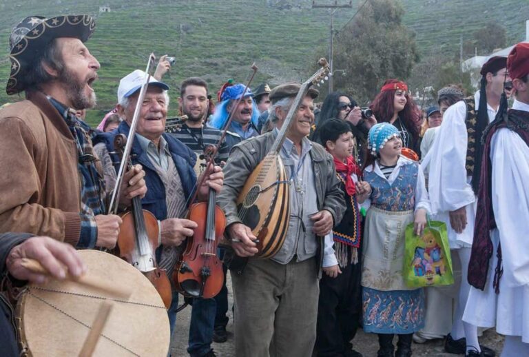 Group of musicians playing traditional string instruments at an outdoor cultural festival, with people in colorful costumes watching.