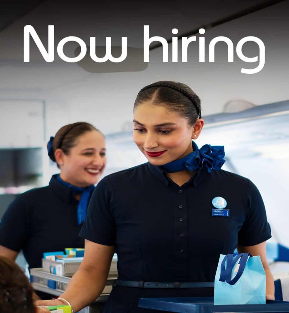 Banner reading 'Now hiring' over two smiling staff members in navy uniforms assisting a customer, suggesting a job opening in hospitality/airline service