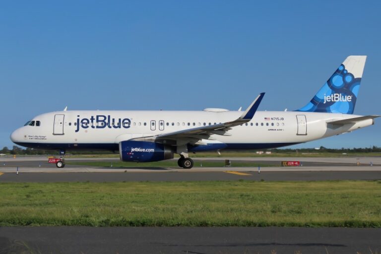 JetBlue passenger jet on the runway seen from the side, with blue tail logo and 'jetBlue' on fuselage