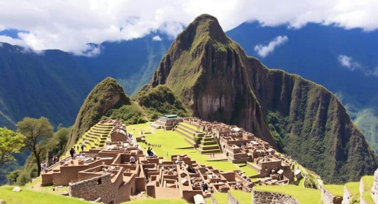 Inca ruins at Machu Picchu on a hillside with stone buildings and terraces, set among green mountains.