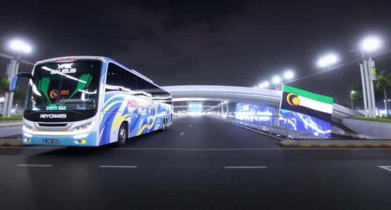 Nighttime view of a blue and white coach bus at a modern terminal with a Namibian flag nearby, illuminated by streetlights.