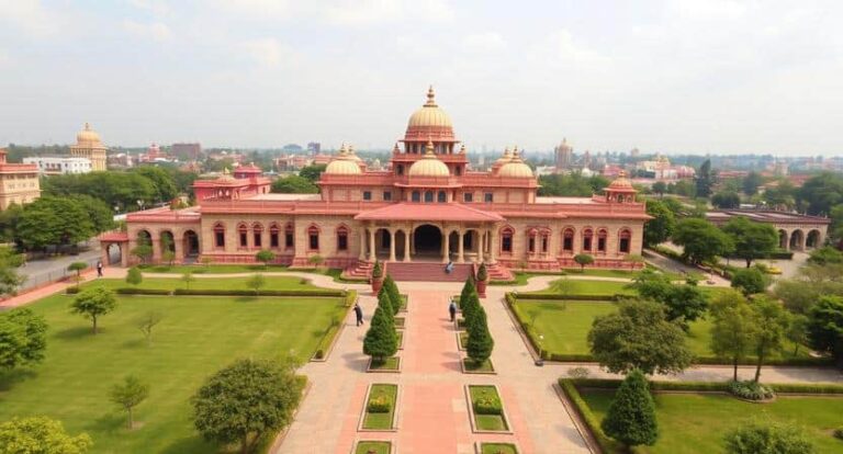 Aerial view of a grand pink-domed palace with symmetrical gardens and a central walkway to the entrance.