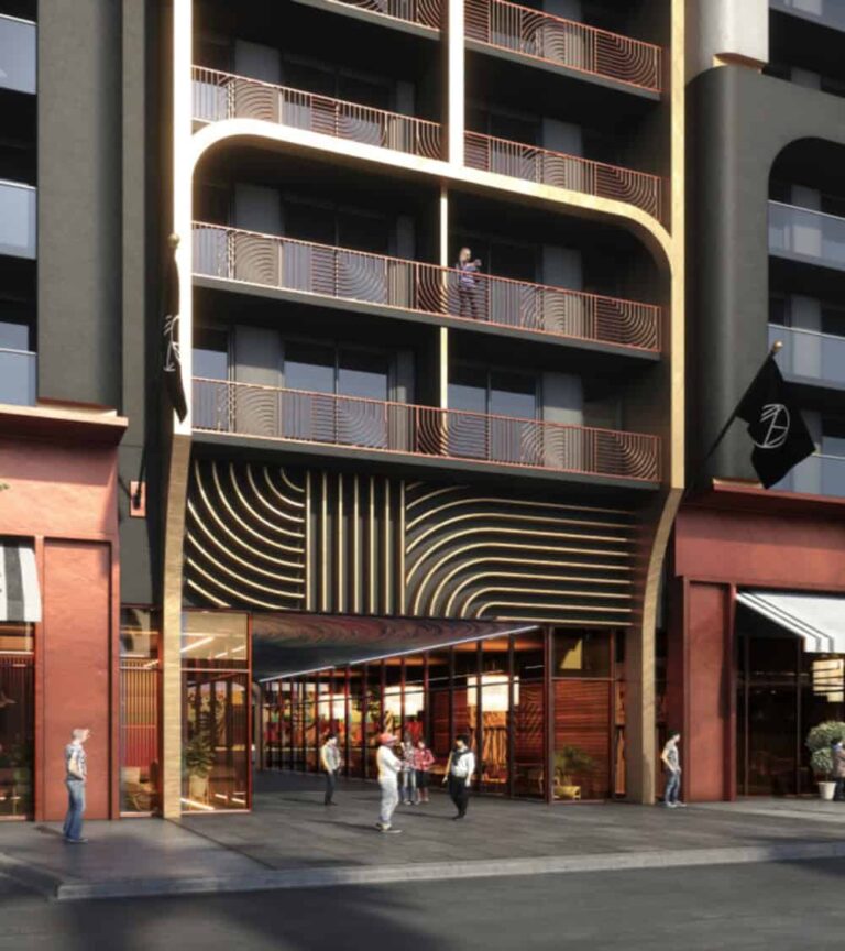 Modern multi-story building with gold-framed arches and curved balconies; ground-floor storefronts with pedestrians on a sidewalk.