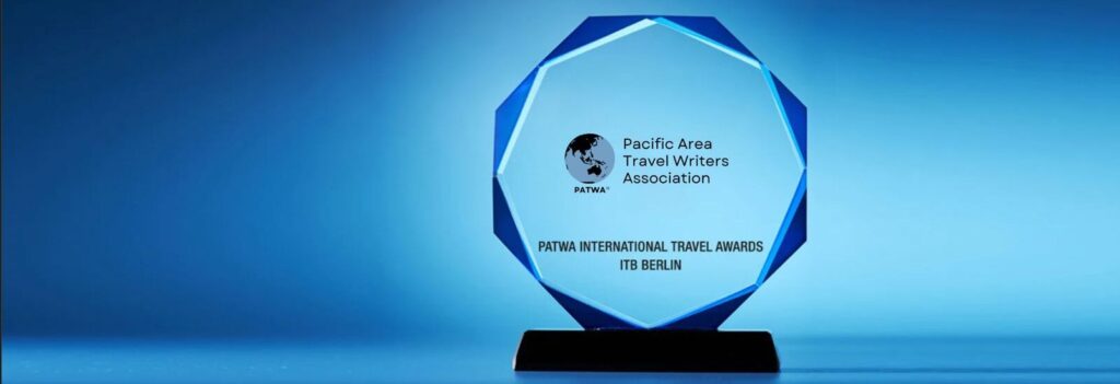 Blue glass octagonal travel award on a black base, with Pacific Area Travel Writers Association (PATWA) and ITB Berlin text and logo.