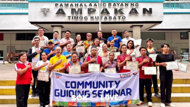 Group of people posing with certificates and a 'Community Guiding Seminar' banner in front of a government building.