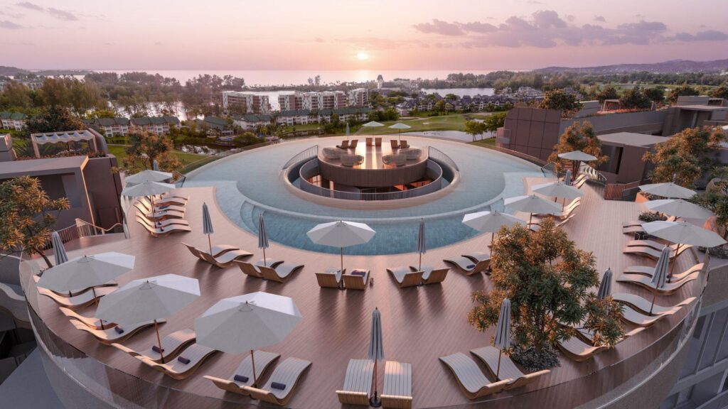 Circular rooftop pool with sun loungers and white umbrellas at sunset, overlooking a resort landscape.