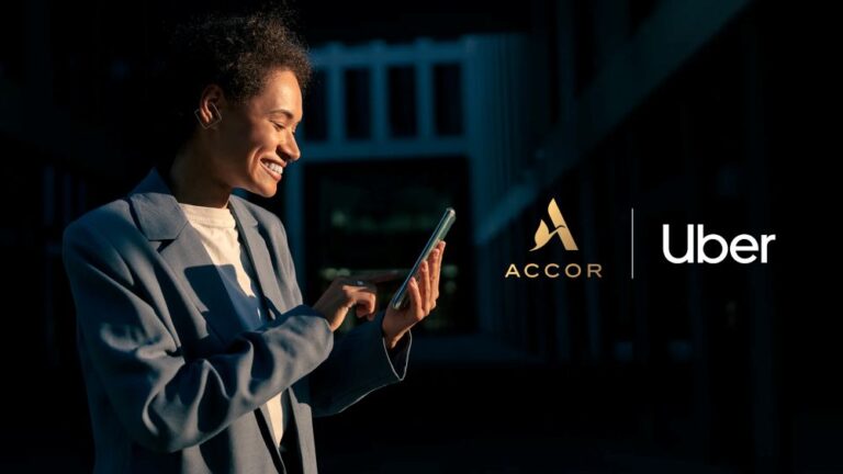 Smiling professional in a blazer uses a smartphone outdoors; ACCOR and Uber logos appear beside her.