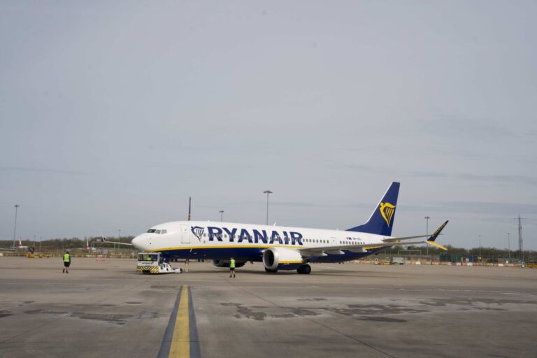 Ryanair passenger jet on the tarmac being prepared for boarding with ground crew nearby.