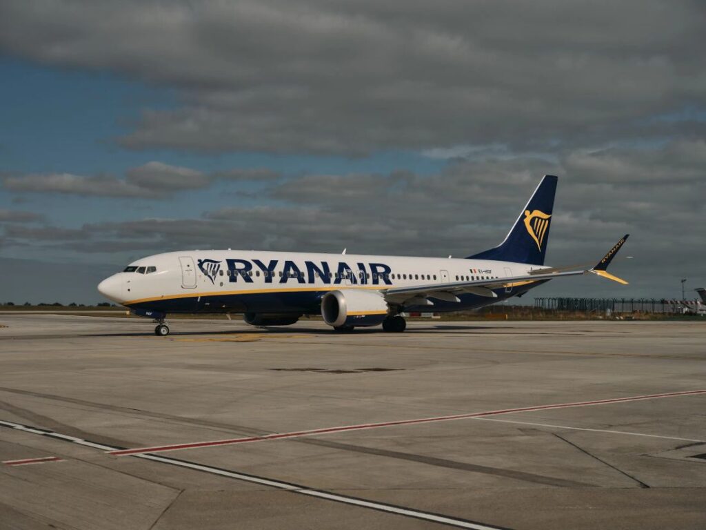 Ryanair Boeing 737 on the tarmac at an airport, front-right view with blue tail and distinctive yellow logo.