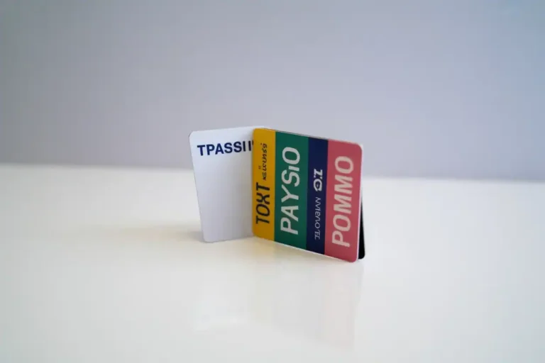 Colorful stack of payment cards standing upright on a white surface, with multicolored stripes visible.
