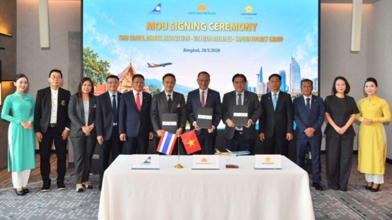 Group of officials at an MOU signing ceremony behind a table with documents and small flags (Thailand and Vietnam) in front of a large banner that reads 'MOU SIGNING CEREMONY'.