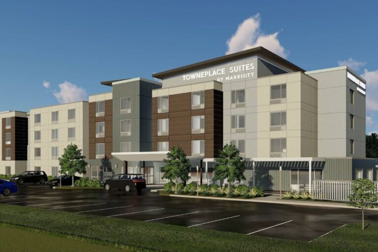 Exterior rendering of a TownePlace Suites by Marriott hotel with a parking lot and landscaped entrance typically used for a storefront page