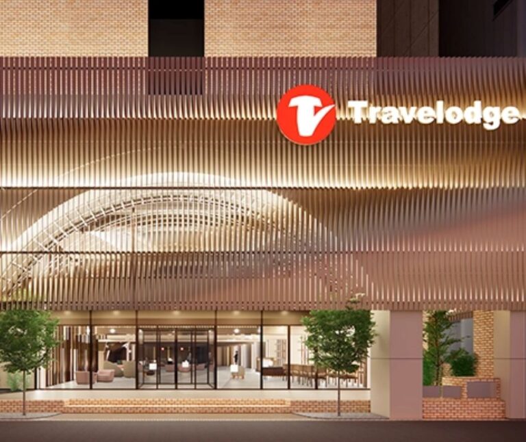 Travelodge hotel exterior at night with illuminated sign and glass lobby entrance
