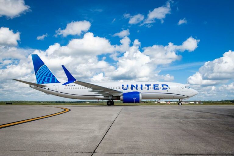 United Airlines passenger jet on a taxiway under a blue sky with scattered clouds; engines and landing gear visible