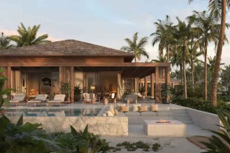Luxury villa with an open living area, stone pool, and palm trees; outdoor seating and a fire pit on the terrace.