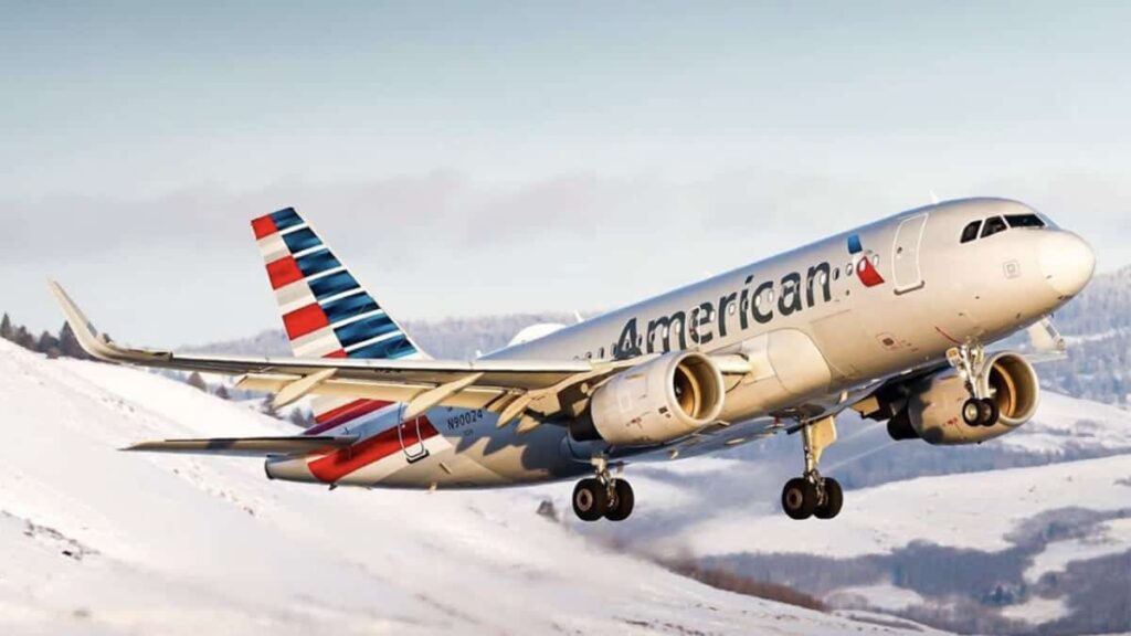 Commercial airliner from American Airlines lifting off from a snow-covered landscape, engines roaring in a wintry scene.