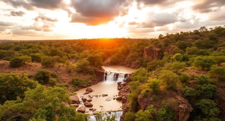 Sunset over a rocky river canyon with a small waterfall and green trees surrounding the gorge