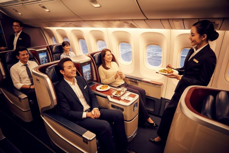 Business-class airplane cabin: a flight attendant serves a plated meal to passengers enjoying the flight while seated and relaxed in premium seats.