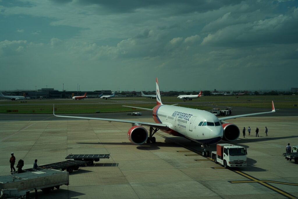 Airline jet on the tarmac being prepared for boarding with ground crew and support vehicles nearby