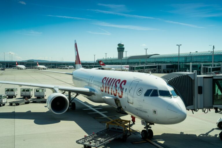 Swiss airliner at a gate with jet bridge connected, on the tarmac