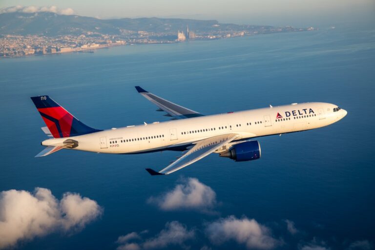 Delta aircraft cruising above the ocean with a coastal city visible in the distance.