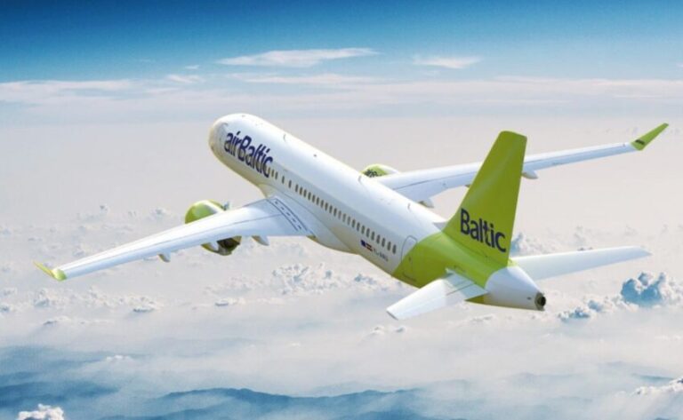 AirBaltic passenger jet flying above clouds, white fuselage with a lime-green tail.