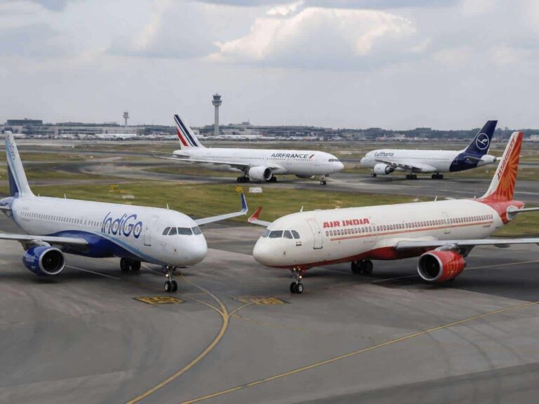 Air India and IndiGo jets on the tarmac with other planes at a busy international airport.