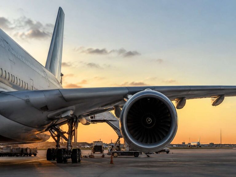 Side view of a large jet with a turbofan engine on the wing at sunset. Readable and informative for identifying the aircraft and its context at dusk.]