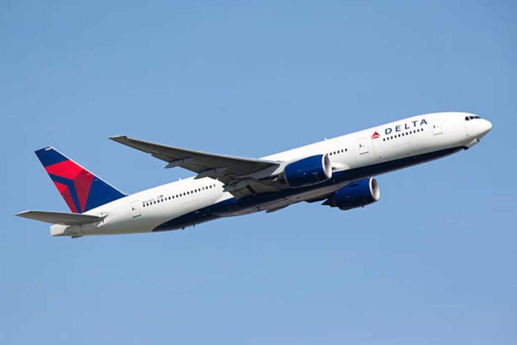 Delta Air Lines commercial jet in flight against a clear blue sky.