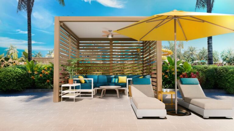 Outdoor cabana with blue seating, yellow umbrella, and lounge chairs on a sunny patio.