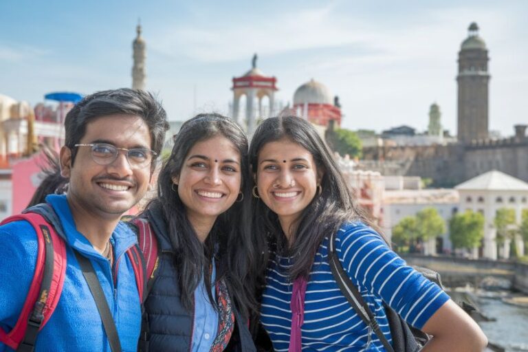 Three friends posing for a sunny selfie with historic domed buildings and towers in the background.