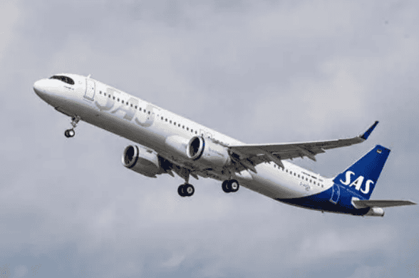 SAS commercial airliner lifting off with blue tail against a cloudy sky, landing gear extended in takeoff pose, white fuselage