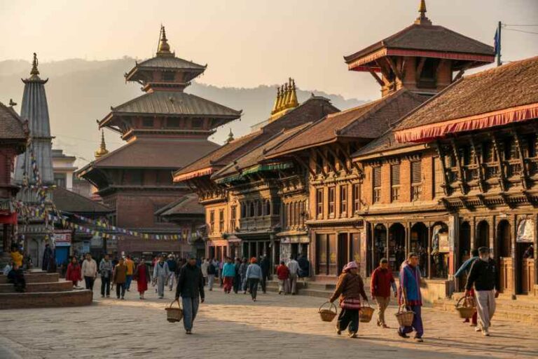 Bustling Nepalese street with wooden pagoda buildings and people carrying baskets at sunset-focused town square.