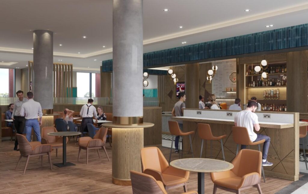 Interior of a stylish cafe with a long bar, round marble tables, and groups of people chatting.