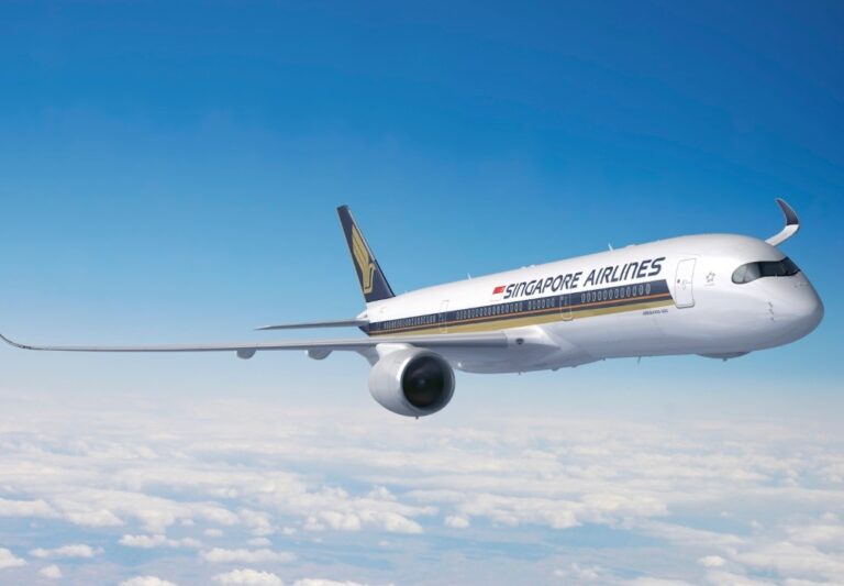 Singapore Airlines jet flying high above clouds against a blue sky