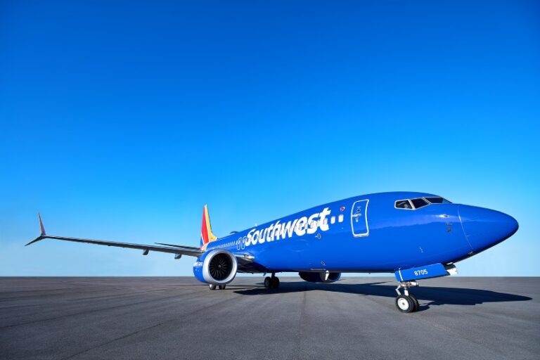 Southwest Airlines blue jet parked on a flat runway under a clear blue sky, nose to the right.