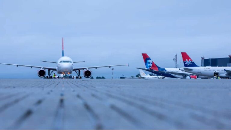 Front-on view of a passenger jet parked on the tarmac with other planes in the background at the airport apron.