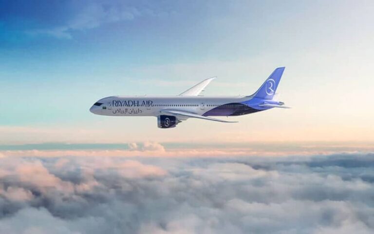 Riyadh Air passenger jet flying above clouds in the sky.