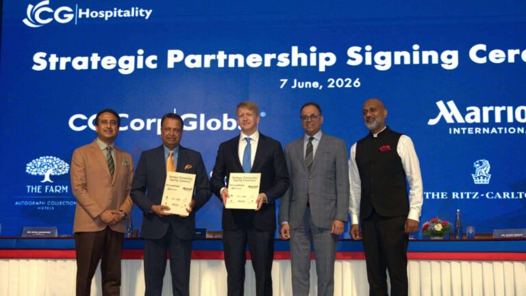 Five men in suits stand on a stage holding signed partnership documents at a Strategic Partnership Signing Ceremony, 7 June 2026, with a blue backdrop.