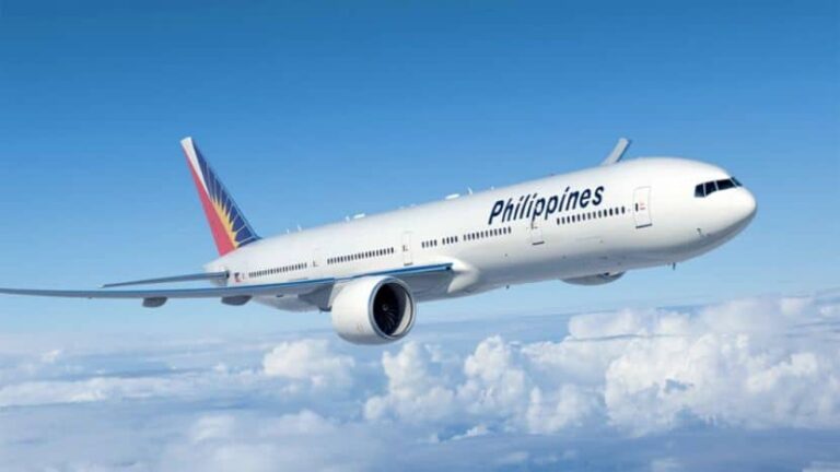 Commercial passenger jet with 'Philippines' branding flying above white clouds under a clear blue sky.